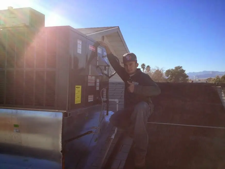 HVAC technician performing AC Tune-Up on a rooftop unit in Boston